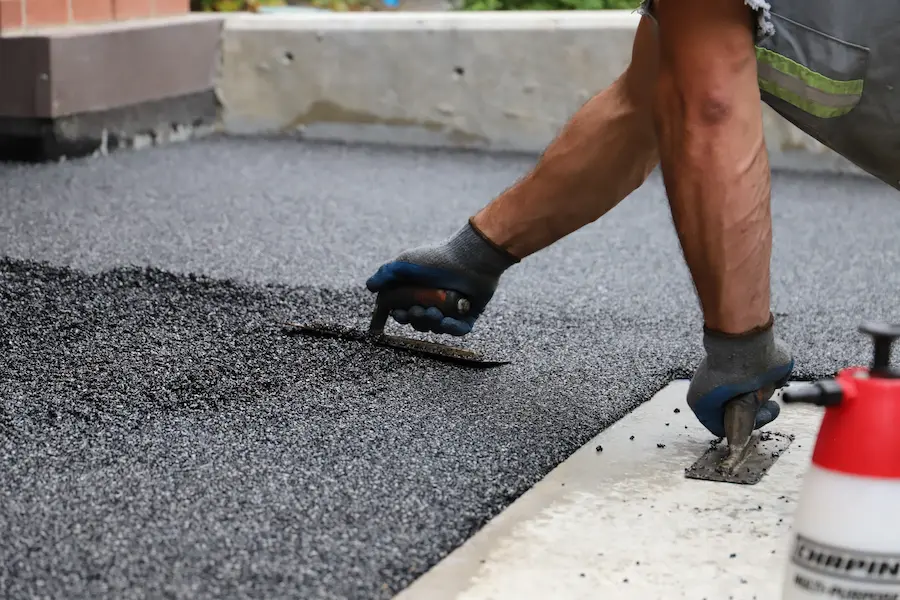 Rubber Stone installation in progress — hand troweling onto a Calgary driveway